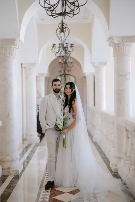 Bride walking through marble-columned hallway in ethereal light at Villa La Joya.