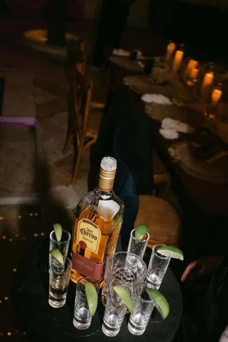 Tequila shots with lime wedges and bottle of Jose Cuervo at festive Villa La Joya wedding reception.