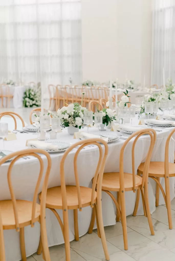 Long reception tables with natural wood chairs and white linens at Luna Escondida.