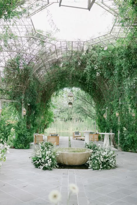 Serene garden lounge with vine-covered archway and pond at Luna Escondida.