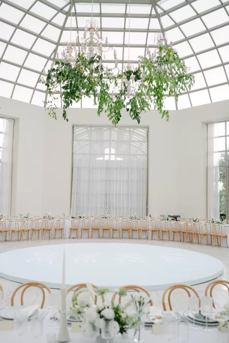 Elegant wedding reception under glass dome at Luna Escondida, with natural light and hanging greenery.