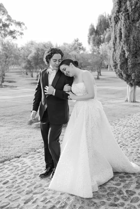 Bride leans on groom’s shoulder during a quiet moment in the gardens of Luna Escondida.