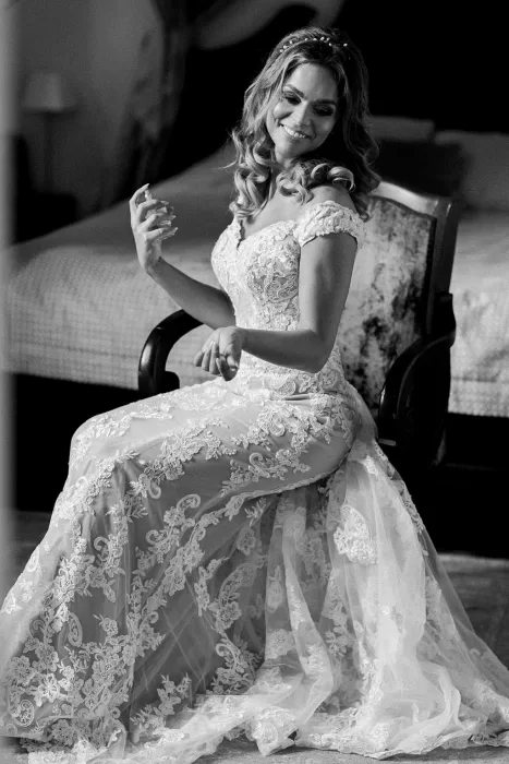 Bride smiling while getting ready in lace gown at Monte Pacis wedding suite