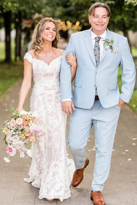 Bride and groom walking arm-in-arm, beaming with joy after wedding at Monte Pacis