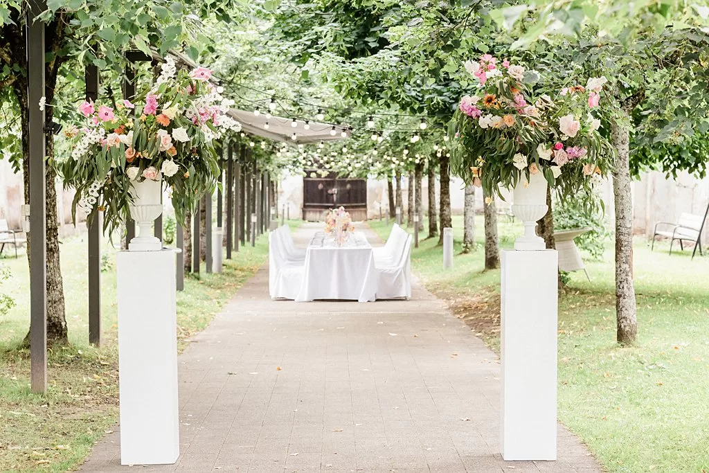 Elegant outdoor reception table under trees with lush floral arrangements at Monte Pacis