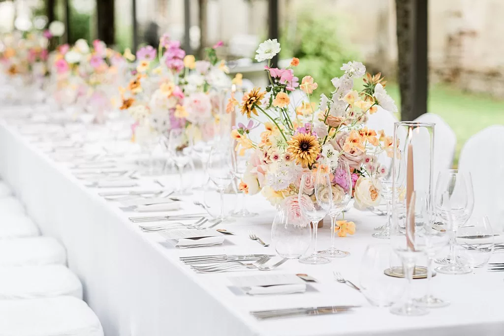 Overflowing flower centrepieces line a long wedding table at Monte Pacis.
