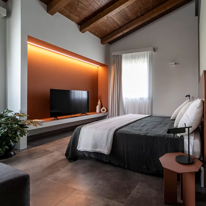 Stylish design corner at Villa Agavi with a wooden sideboard, warm-toned lamp, and modern abstract wall art.