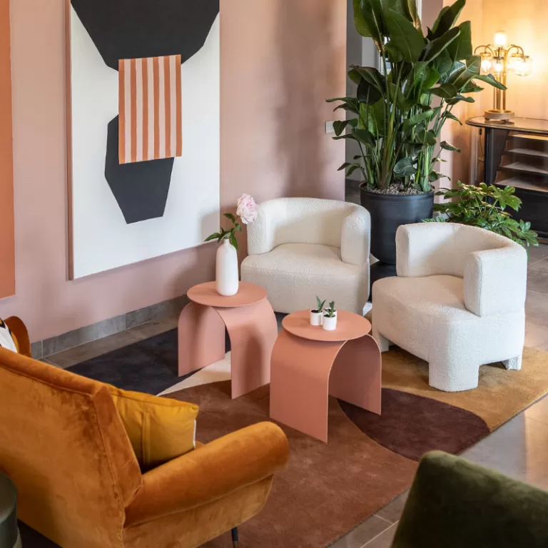 Contemporary lounge at Villa Agavi with soft armchairs, abstract art, and earthy tones creating a calm, stylish atmosphere.