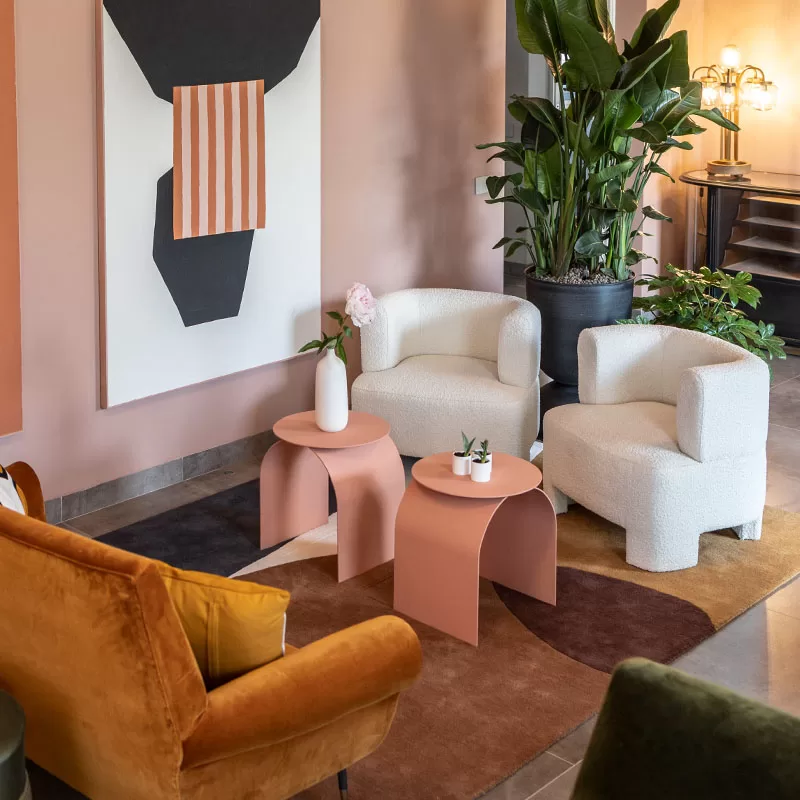 Contemporary lounge at Villa Agavi with soft armchairs, abstract art, and earthy tones creating a calm, stylish atmosphere.
