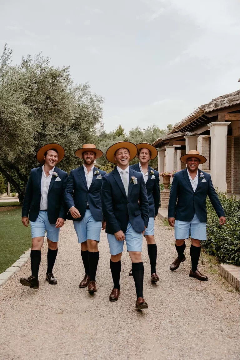 Groomsmen in blue jackets and Spanish hats walking together at Cigarral de las Mercedes.
