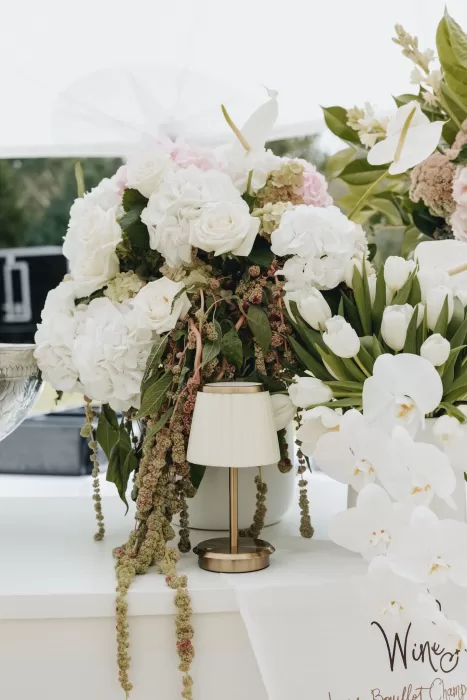 Elegant floral display with white roses, orchids, and tulips styled on the bar at Le Mas Barossa.