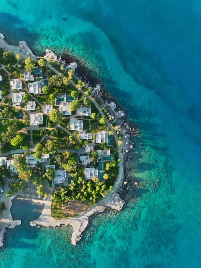 Aerial view of Minos Beach Art Hotel surrounded by turquoise waters.