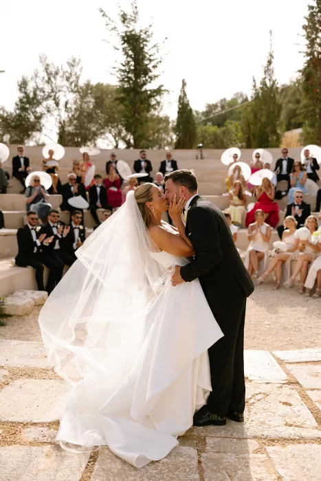 Bride and groom share a romantic kiss during their outdoor ceremony at Cases de Sa Fonseca amphitheater.