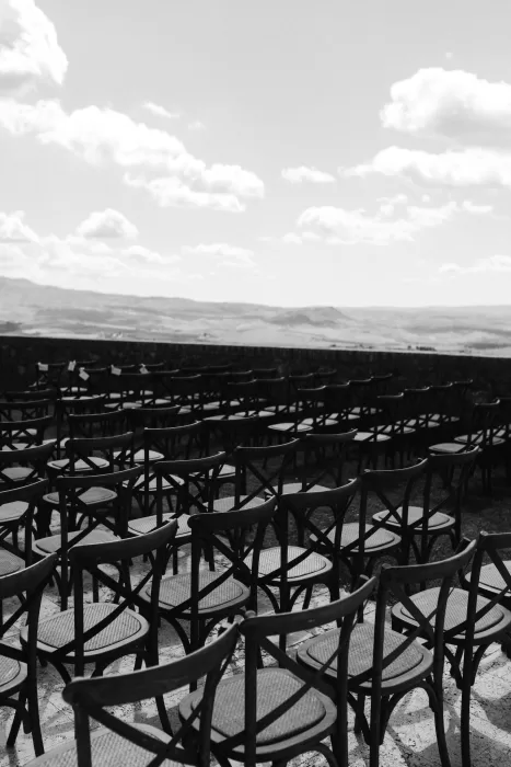 Rows of wooden chairs arranged for an outdoor wedding ceremony at Castello di Velona.