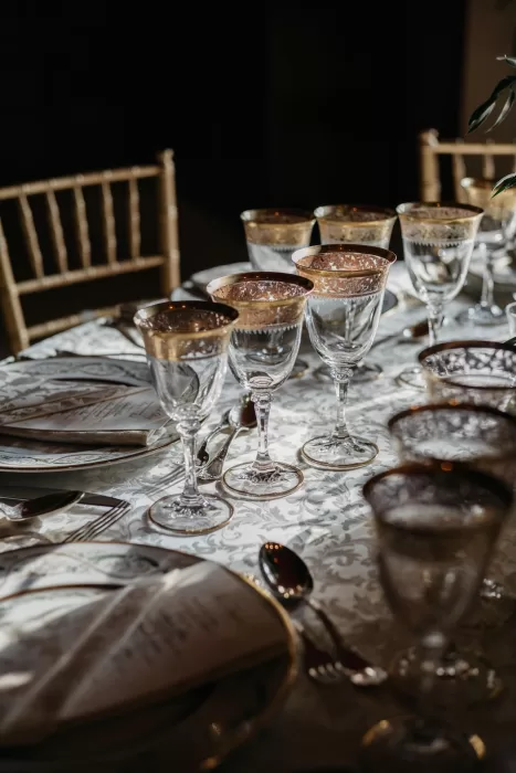 Luxurious wedding reception table at Castello di Velona with gold-rimmed glassware and patterned linens.