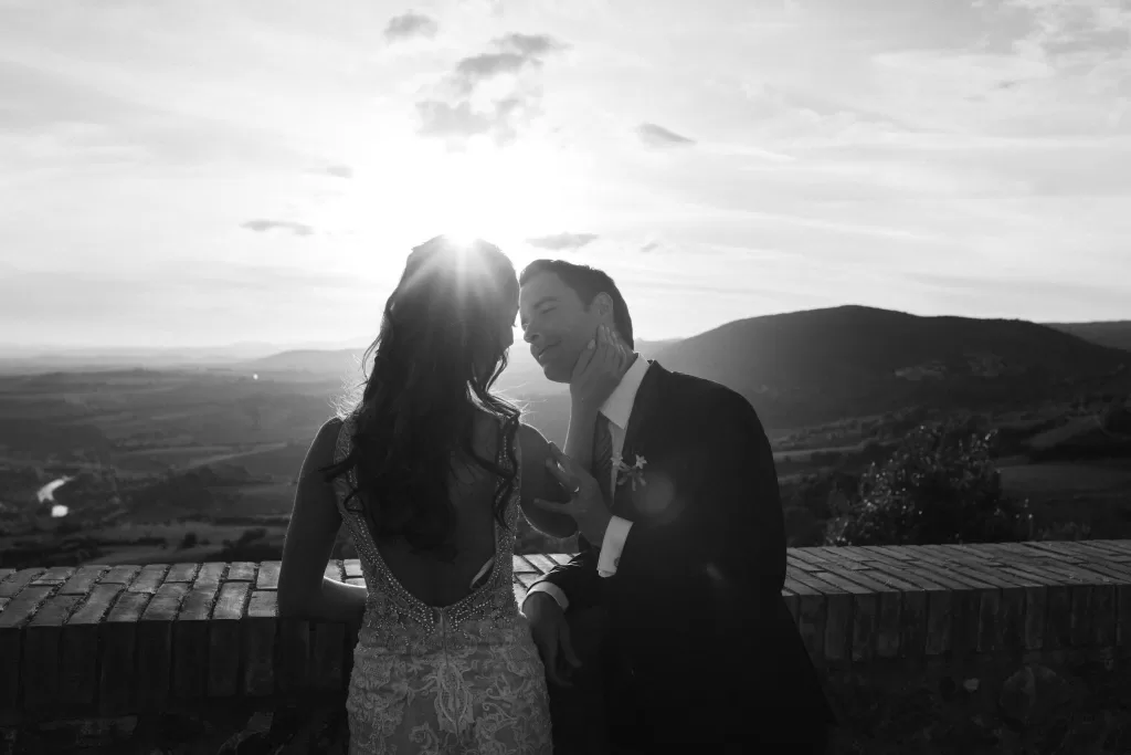 Bride and groom at Castello di Velona sharing a moment at sunset with rolling hills in the background.