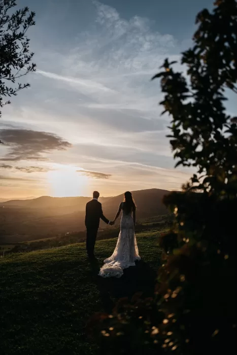Bride and groom at Castello di Velona sharing a moment at sunset with rolling hills in the background.
