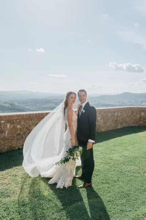 Bride and groom standing together on the lawn at Castello di Velona with sweeping countryside views.