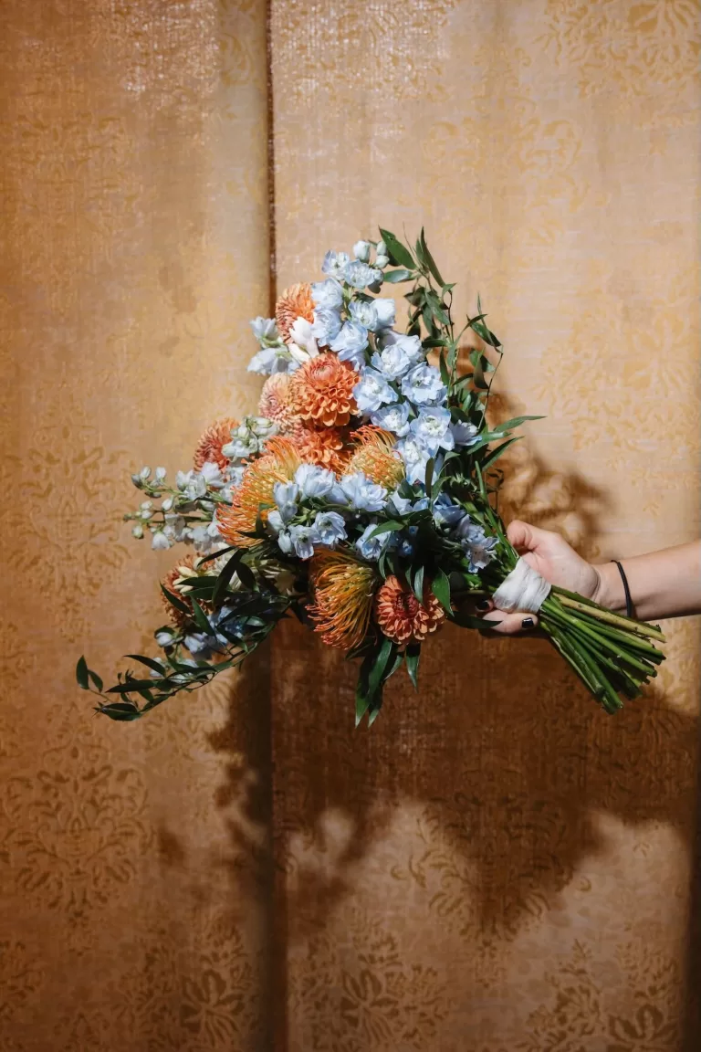 Bold bridal bouquet with orange dahlias and blue delphiniums at Finca Son Collell