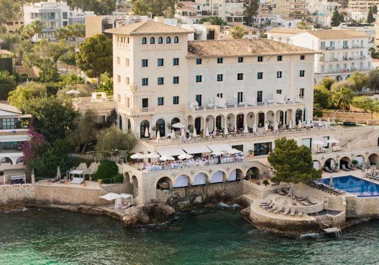 Aerial view of Hospes Maricel & Spa, a historic cliffside hotel overlooking the Mediterranean Sea.