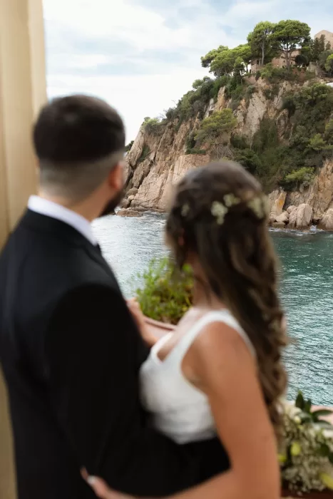 Couple gazing at the dramatic cliffs and sparkling sea from Marimurtra Botanical Garden.