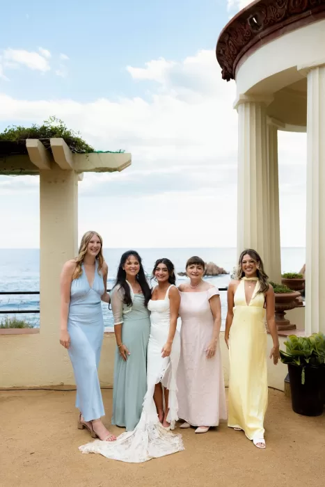 Bride posing with her family in pastel dresses at Marimurtra Botanical Garden overlooking the sea.