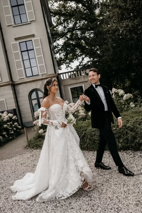 Groom leading the bride through the garden paths of Parc Broekhuizen.