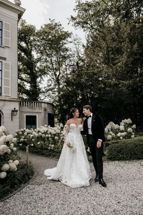 Bride and groom walking together through the blooming gardens at Parc Broekhuizen.