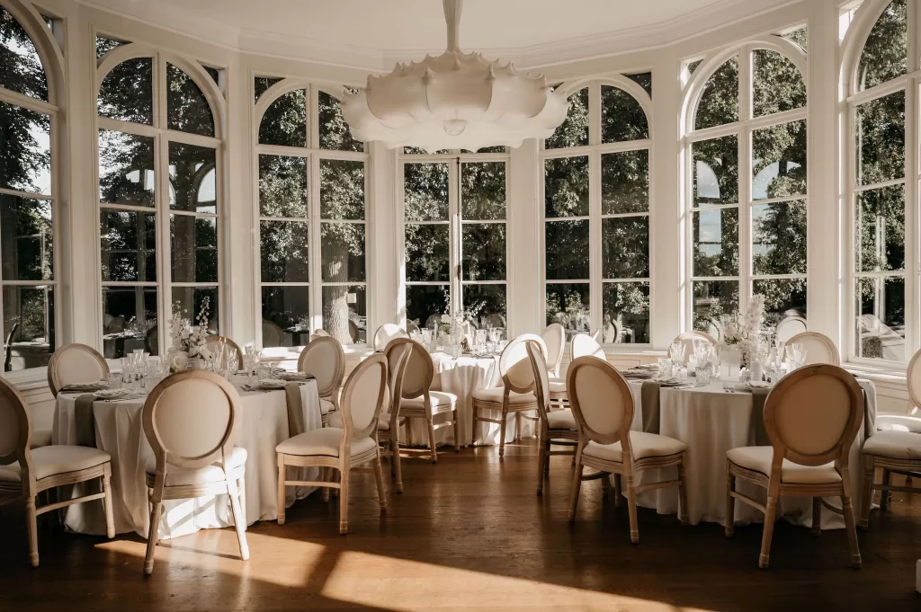 Elegant wedding reception setup with round tables and natural light at Parc Broekhuizen.