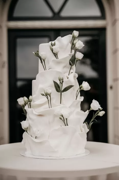 Modern white wedding cake decorated with delicate flowers at Parc Broekhuizen.