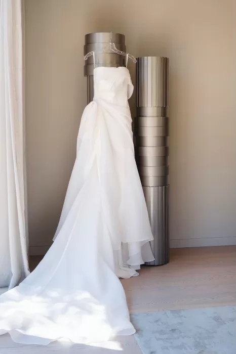 Elegant strapless wedding gown displayed on a hanger in a modern room at Six Senses Douro Valley.