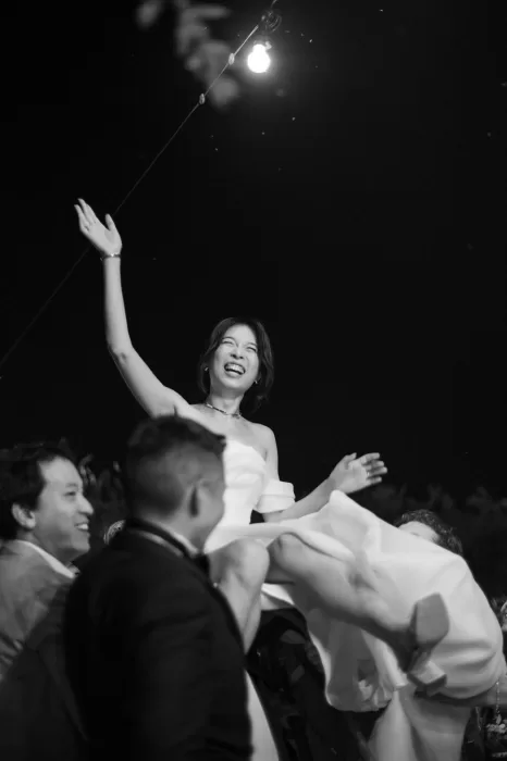 Bride lifted in the air by wedding guests during evening celebrations at Six Senses Douro Valley.