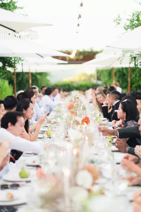 Wedding guests seated at a long candlelit table under parasols at Six Senses Douro Valley.