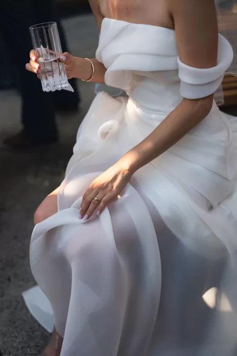 Close-up of bride’s dress and engagement ring while holding a glass at Six Senses Douro Valley.
