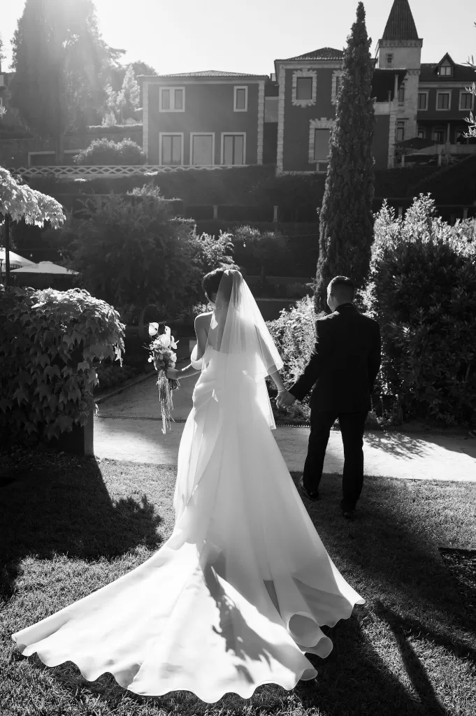 Bride and groom walking hand in hand through the gardens at Six Senses Douro Valley.