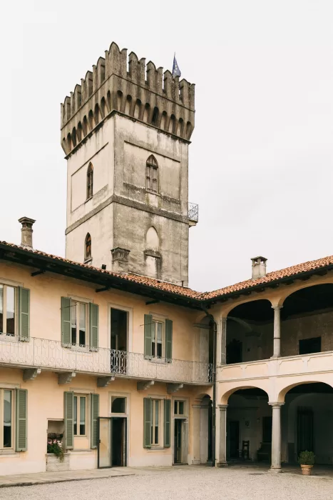 Historic stone tower rising above the elegant courtyard of Villa Bossi.