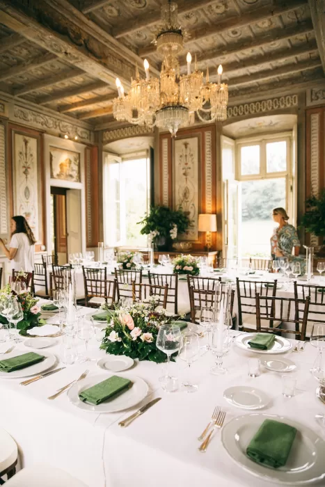Sophisticated reception setup with chandeliers and floral arrangements inside Villa Bossi.