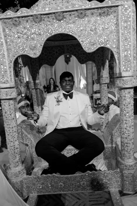 Groom seated in a traditional Moroccan carriage during the lively wedding celebration at Beldi Country Club.