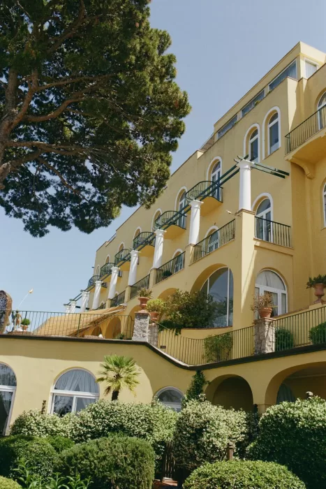 Classic Mediterranean architecture of Caesar Augustus in Capri, featuring arched windows, white columns, and terraced greenery.