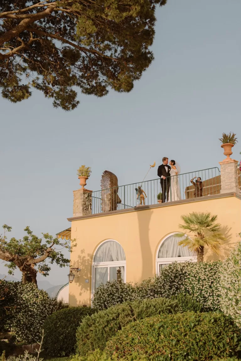 Bride and groom sharing a moment on the rooftop terrace of Caesar Augustus Capri surrounded by Mediterranean gardens and soft golden light.