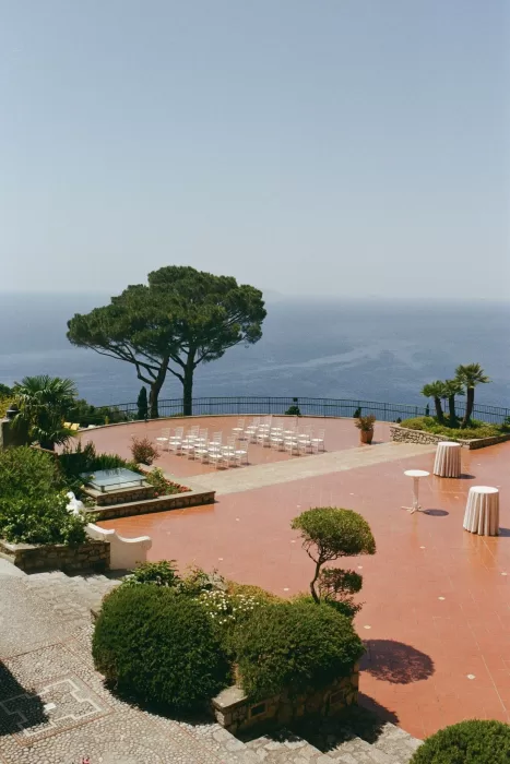 Ocean-view terrace at Caesar Augustus Capri prepared for a wedding ceremony with white chairs and manicured gardens.