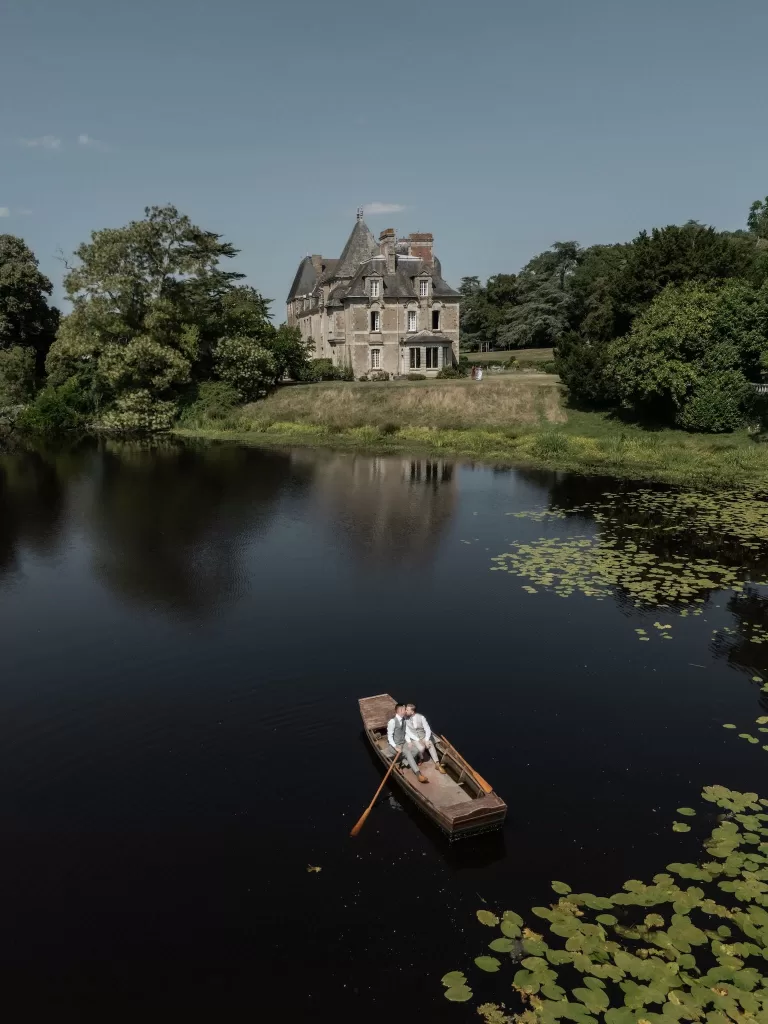 Château de Pordor overlooking its peaceful lake as the grooms drift by in a wooden rowboat.