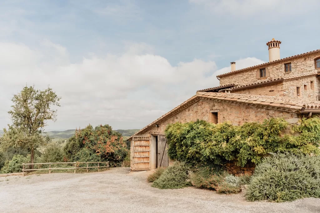 The countryside view of This Must Be The Place with stone walls and surrounding greenery under a bright sky.