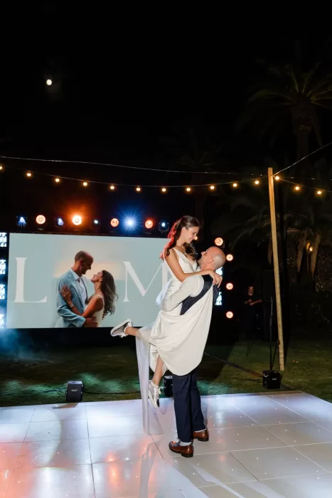 Newlyweds share their first dance under string lights and a glowing moonlit sky at Finca la Concepción.