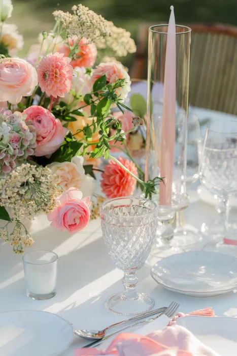 Elegant wedding table setting at Finca la Concepción with pastel roses, dahlias, and crystal glassware in the afternoon light.