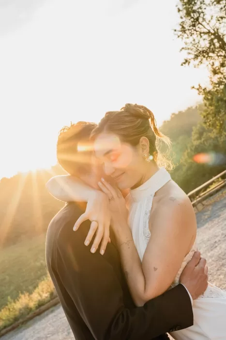 The bride and groom embrace tenderly in the glow of golden-hour sunlight at This Must Be The Place.