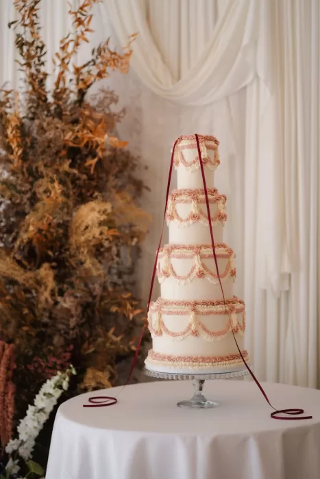 Hampton Manor reception hall with elegant cake table framed by mauve details and modern glass ceiling.