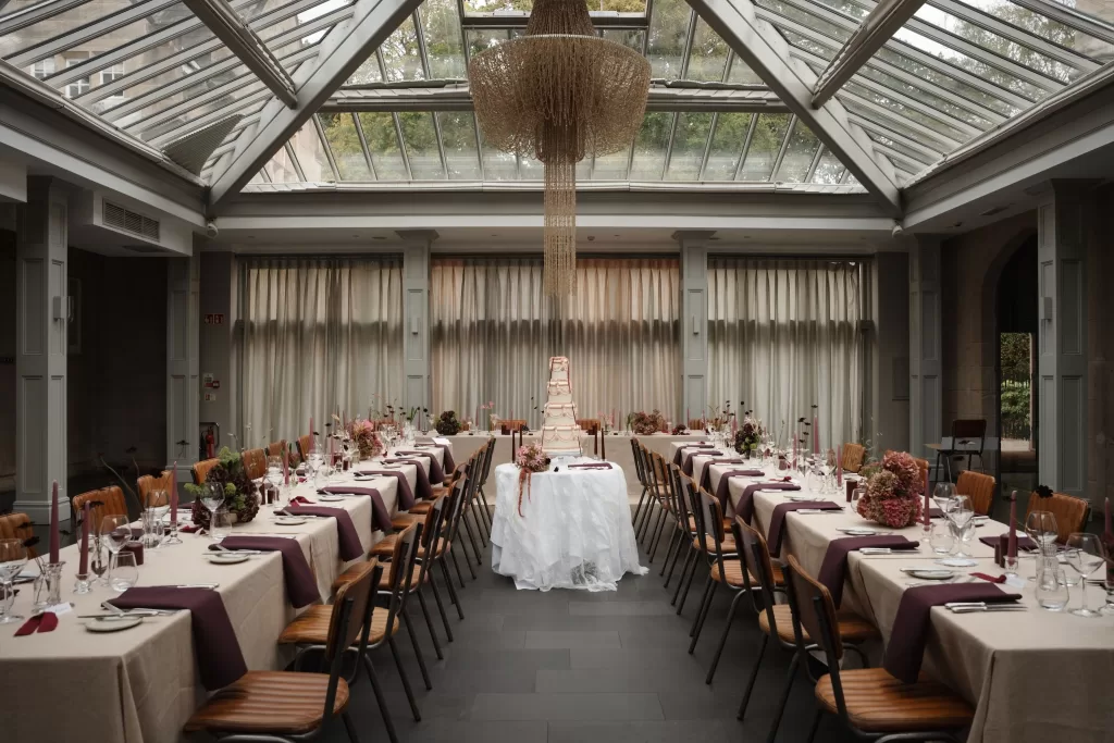 Hampton Manor reception hall with elegant cake table framed by mauve details and modern glass ceiling.