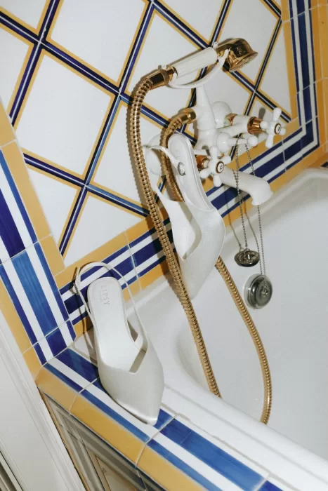 Elegant white bridal heels resting on blue and yellow tiled bath edge at Herdade do Peru.