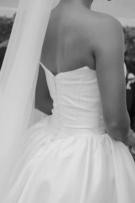 Black and white close-up of the bride’s elegant strapless gown and veil at Hospes Maricel & Spa.